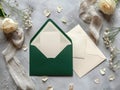 Green envelope with a white card sits on a table next to a white envelope Royalty Free Stock Photo