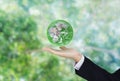 Green and environmental global business. Businessman hand holding globe with green bokeh background. Element of this image are fur