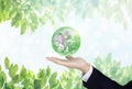 Green and environmental global business. Businessman hand holding globe with leaves background. Element of this image are furnishe Royalty Free Stock Photo