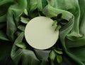 Green fabric backdrop with circular blank space surrounded by leaves for design projects, mockup