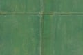 Green faded metal wall with cross from metal stripes on the middle