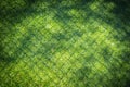Green fake grass with fence shadow for security park. Royalty Free Stock Photo