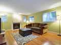 Green family room with fireplace, sofa with ottoman