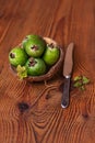 Green feijoa in a coconut shell hulf on a wooden background. Ripe tropical fruits, raw vegan food.Vitamin C. Copy space Royalty Free Stock Photo