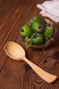 Green feijoa in a coconut shell hulf on a wooden background. Ripe tropical fruits, raw vegan food.Vitamin C. Copy space Royalty Free Stock Photo