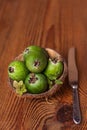 Green feijoa in a coconut shell hulf on a wooden background. Ripe tropical fruits, raw vegan food.Vitamin C. Copy space Royalty Free Stock Photo