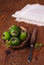 Green feijoa in a coconut shell hulf on a wooden background. Ripe tropical fruits, raw vegan food.Vitamin C. Copy space