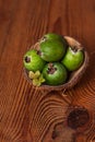 Green feijoa in a coconut shell hulf on a wooden background. Ripe tropical fruits, raw vegan food.Vitamin C. Copy space Royalty Free Stock Photo