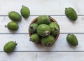 Green feijoa fruits in a cork plate on a light white wooden table. Tropical fruit feijoa. Set of ripe feijoa fruits. the view from