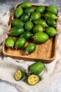 Green feijoa fruits in a wooden plate on a grey  background. Tropical fruit feijoa. Top view Royalty Free Stock Photo