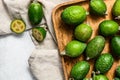 Green feijoa fruits in a wooden plate on  a grey background. Tropical fruit feijoa. Top view Royalty Free Stock Photo