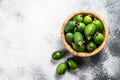 Green feijoa fruits in a wooden plate on a grey  background. Tropical fruit feijoa. Top view. Space for text Royalty Free Stock Photo