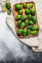 Green feijoa fruits in a wooden plate on a grey  background. Tropical fruit feijoa. Top view. Space for text Royalty Free Stock Photo