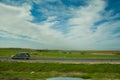 Green feilds and highway mooving cars veiw from side. The road along fields and forests