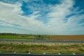 Green feilds and highway mooving cars veiw from side. The road along fields and forests