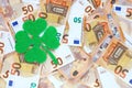 Green felt four leaf clover on 50 fifty euro banknotes background. Lucky talisman. Saint Patricks day.