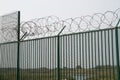 Green fence with razor wire guarding French ferry terminal.