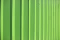 Green fence. Ribbed metal. Light green background Royalty Free Stock Photo
