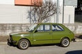 Green Fiat 127, supermini car of the Seventies at the roadside.