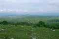 Green field against the background of the cloudy sky. Sipovo, Bosnia and Herzegovina. Royalty Free Stock Photo