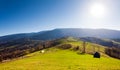 Green field with barn, mountains on background