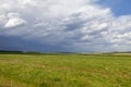 Green field and blue sky. Beautiful view of the grass and the hills on a sunny summer day. Royalty Free Stock Photo