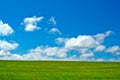 Green field, blue sky and white clouds Royalty Free Stock Photo