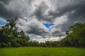 Green field with dramatic rainy clouds