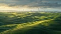 Green field and hills landscape with wind turbines in a sunny day with blue sky and puffy clouds Royalty Free Stock Photo