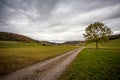 a green field with houses in the distance and a cloudy sky above it, with a few clouds in the sky Royalty Free Stock Photo