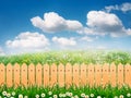 Green field landscape from backyard with daisy flowers and wooden picket fence Royalty Free Stock Photo