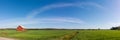 Green field panorama with red barn Royalty Free Stock Photo