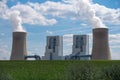 Green field with a power plant for energy generation in the background Royalty Free Stock Photo