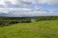 Green field with river under blue sky Royalty Free Stock Photo