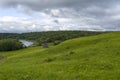 Green field with river under blue sky Royalty Free Stock Photo