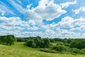 Green field, trees and blue sky with white clouds. Royalty Free Stock Photo