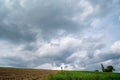 Green field under a cloudy sky with a small structure in the distance. Bad Schallerbach, Austria Royalty Free Stock Photo