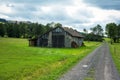 Green fields with barn and small road and cloudy sky Royalty Free Stock Photo
