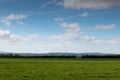 Green fields with blue cloudy skies Royalty Free Stock Photo