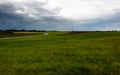Green fields in the countryside under a cloudy sky. Royalty Free Stock Photo
