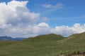 Green fields and hills with mountains in background