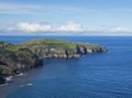 Green fields pasture and coastal cliffs and blue ocean and sky horizon at north coast of sao miguel island, Azores Royalty Free Stock Photo