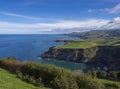 Green fields pasture and coastal cliffs and blue ocean and sky horizon at north coast of sao miguel island, Azores Royalty Free Stock Photo