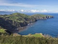 Green fields pasture and coastal cliffs and blue ocean and sky horizon at north coast of sao miguel island, Azores Royalty Free Stock Photo