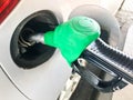 Green filling pistol stuck in the gas tank of a car at a gas station. The process of filling the car with fuel, gasoline, diesel Royalty Free Stock Photo