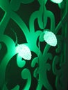 Green fir cones Christmas lights garland on dark background. Christmas or new year led lights garland. Blurred green glowing light Royalty Free Stock Photo