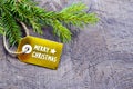 Green fir tree branch with Merry Christmas tag on old wooden background.Winter holidays,New Year festive decoration concept. Royalty Free Stock Photo