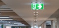 Green fire escape sign hang on the ceiling in the office. Royalty Free Stock Photo