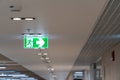 Green fire escape sign hang on the ceiling in the office. Royalty Free Stock Photo