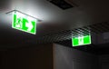 Green fire escape sign hang on the ceiling in the office at night Royalty Free Stock Photo